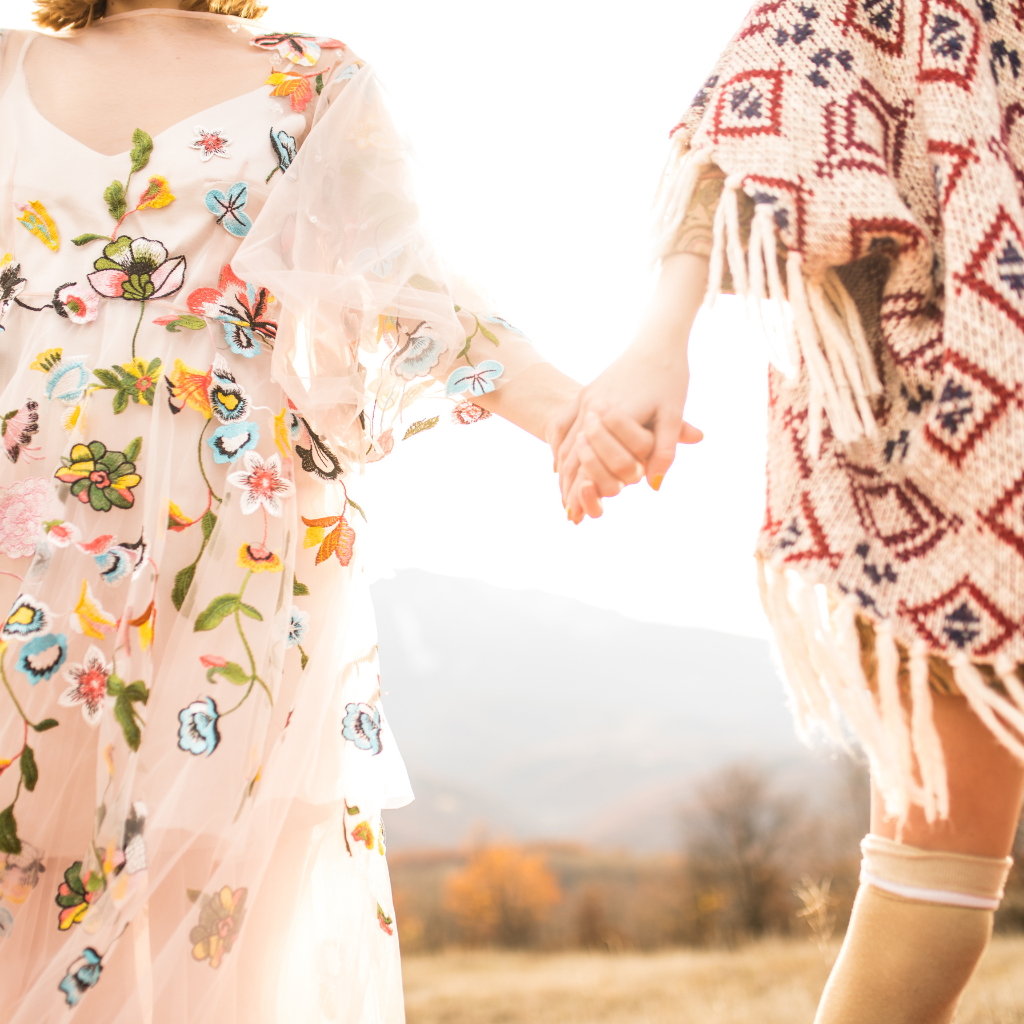 Zwei Frauen halten sich an den Händen, Blümchenkleider, Sommer